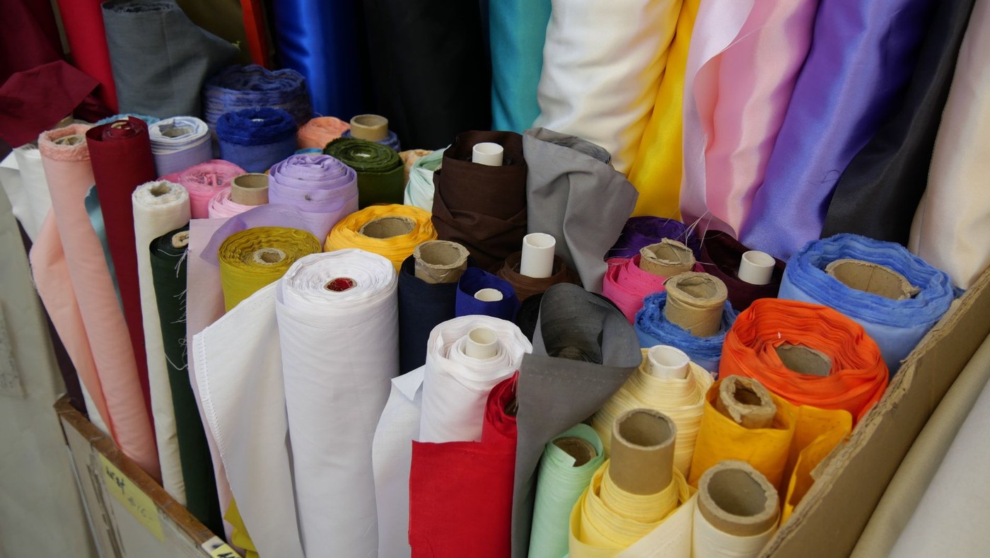 Textile fabric rolls and garment samples in warehouse